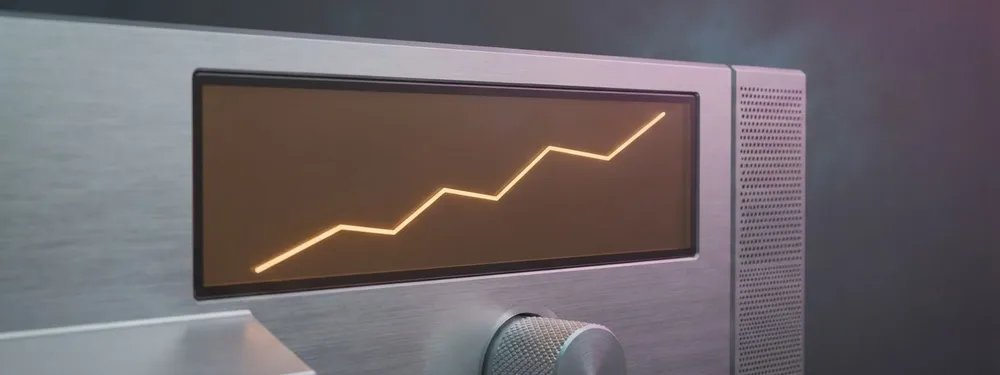 A thin amber screen on a brushed aluminium console showing a rising line